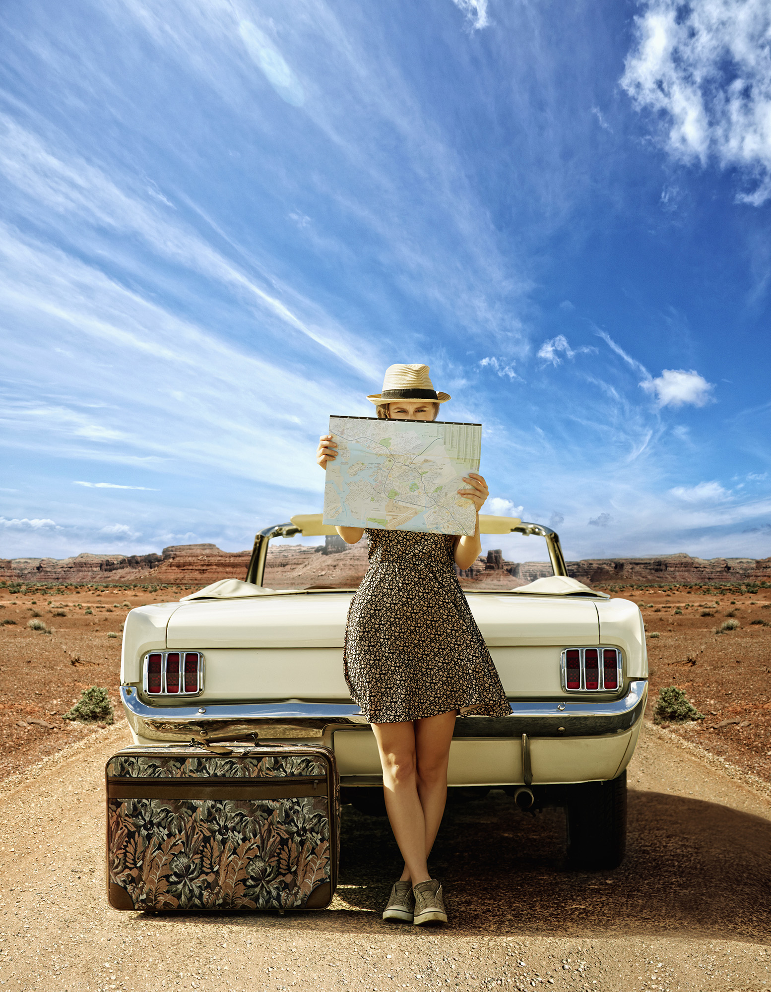 A caucasian woman with convertible reading map on a remote road. If you plan to purchase a used car in Melbourne, have it inspected by a professional like German Precision. Contact now!