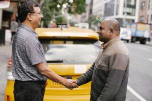 Two people shaking hands behind a yellow car. If you plan to buy a used car, read these questions to ask first! Contact German Precision for a professional pre-purchase car inspection in Melbourne.