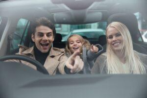 A happy family in a car. Thinking of buying a used family car in Melbourne? Read these tips first or hire a professional pre-purchase car inspector like German Precision!